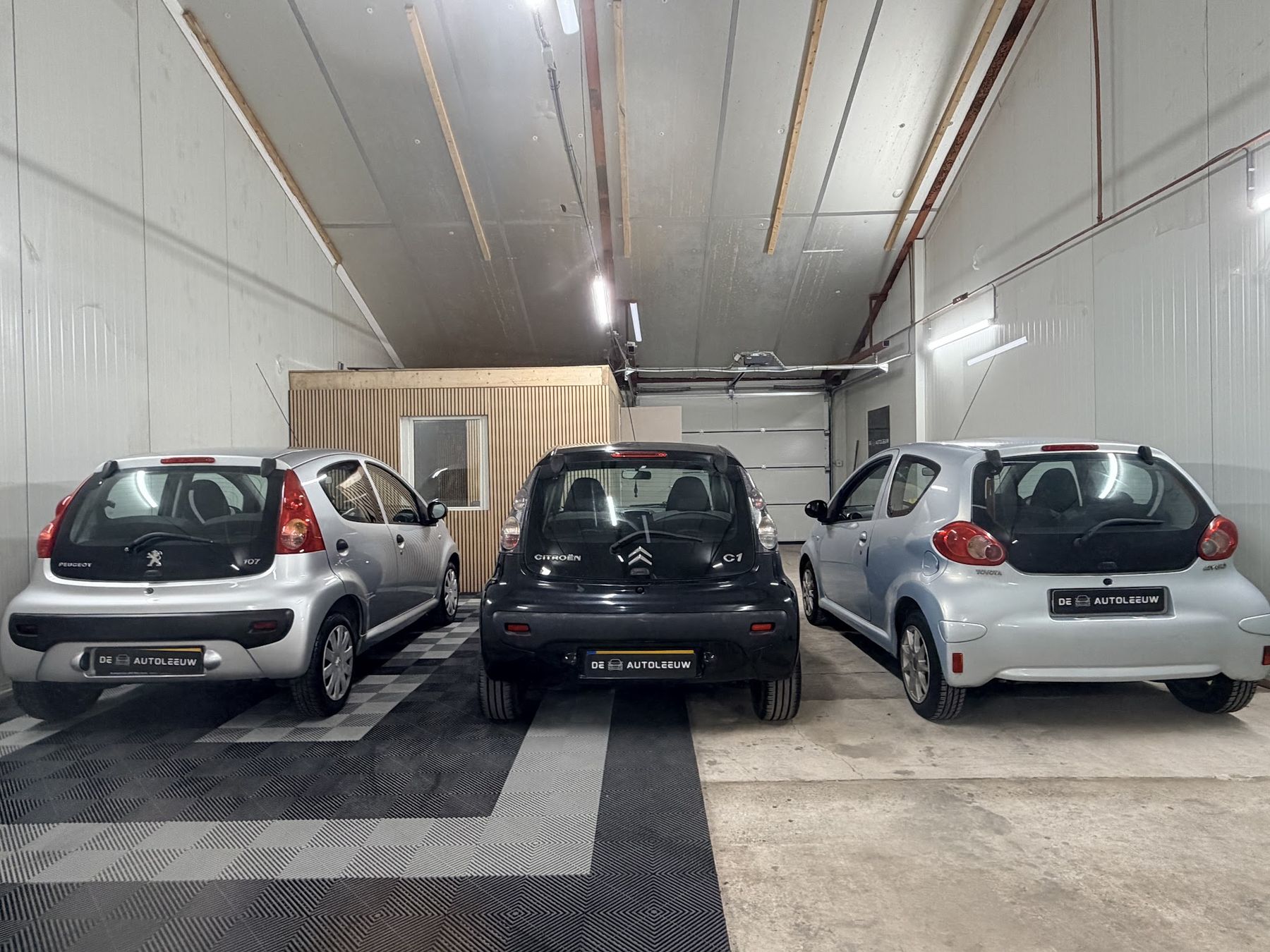 Drie kleine auto’s op een rij, van achteren gezien