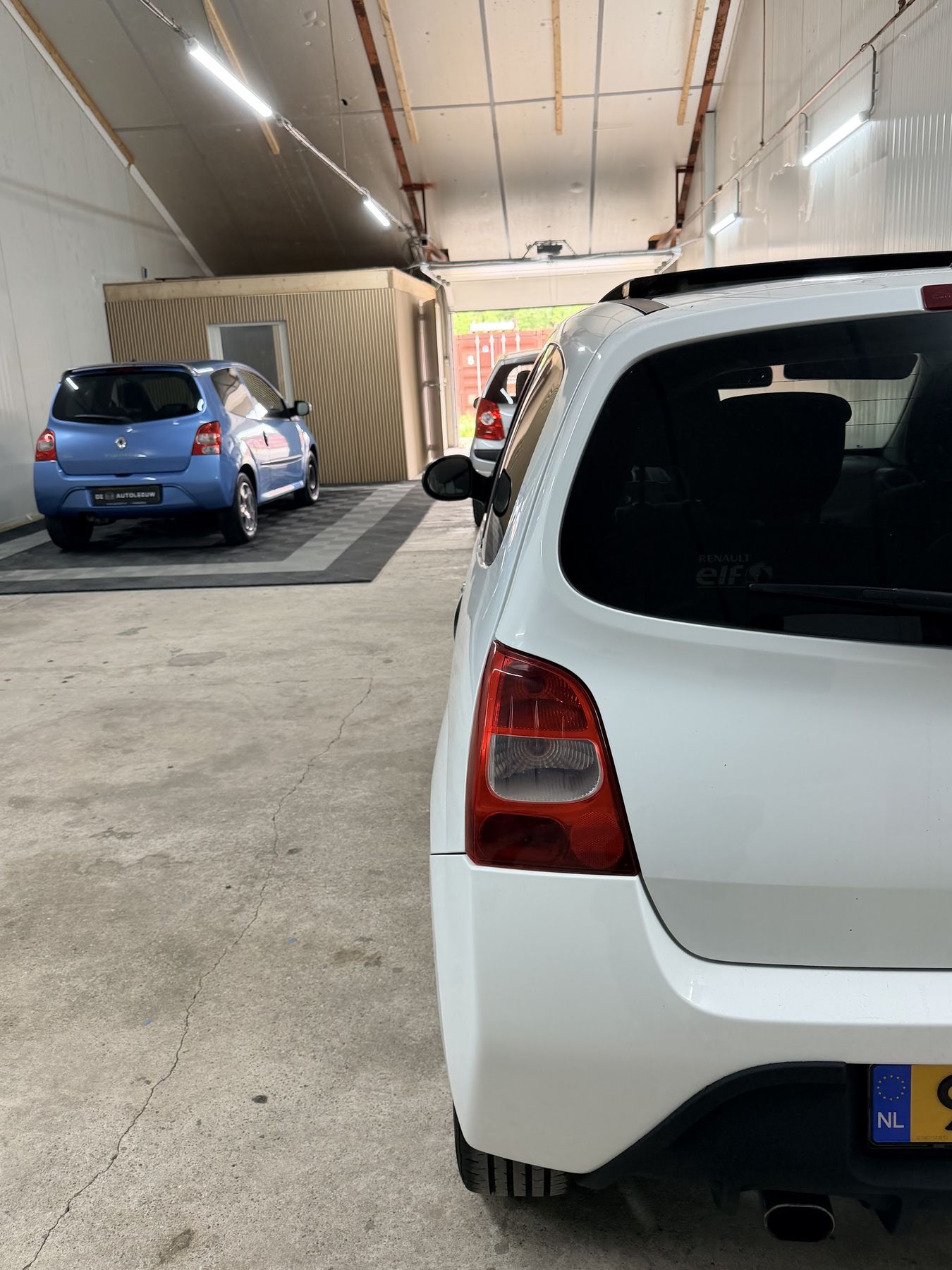 Achterkant van een witte Renault Twingo in de showroom