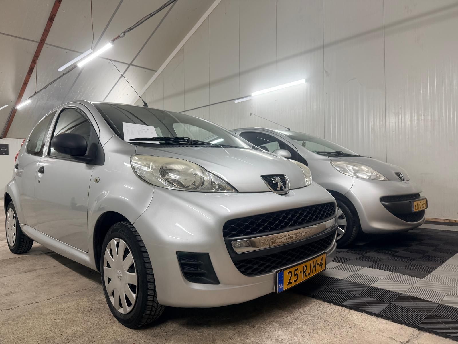 Twee zilveren Peugeot 107’s in de showroom
